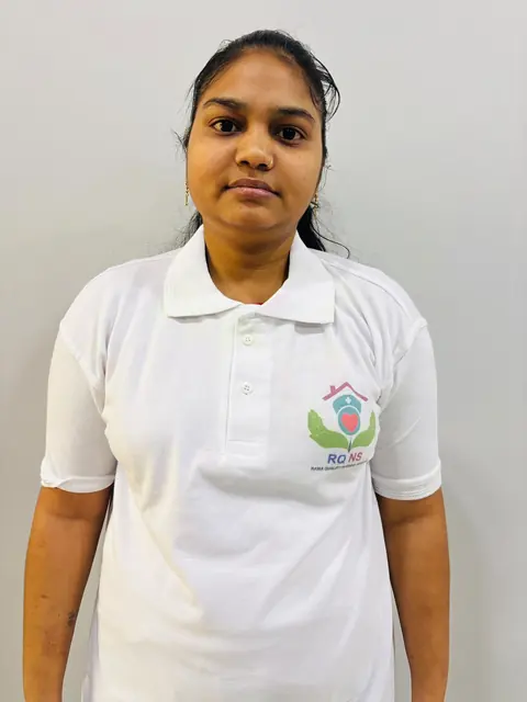 Female caregiver in a white uniform polo with the company logo