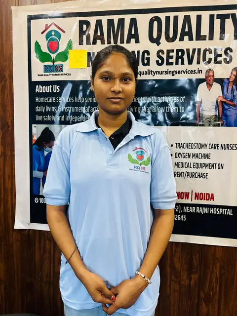 Team member in a blue uniform standing in front of the company banner